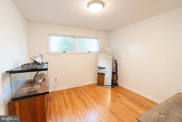 misc room with baseboards, light wood-style flooring, and visible vents