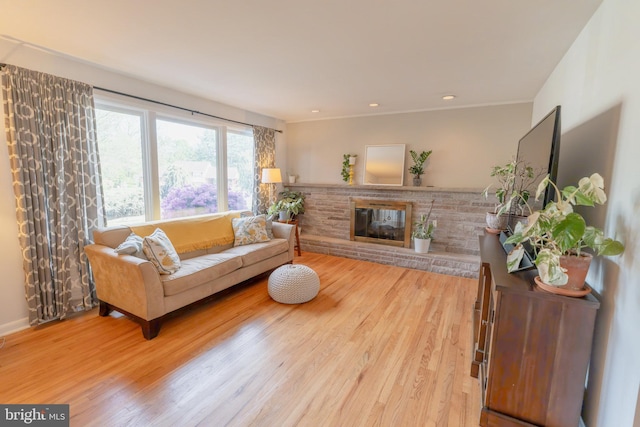 living room featuring a brick fireplace and wood finished floors
