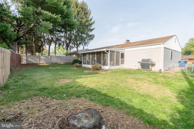 view of yard with a sunroom and a fenced backyard