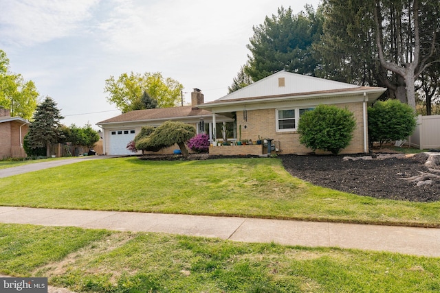 ranch-style home featuring driveway, a chimney, a front yard, a garage, and brick siding