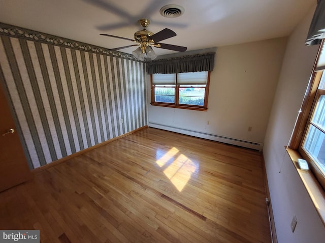 212 University Dr, Mont Alto, PA 17237 - empty room featuring baseboard heating, wallpapered walls, visible vents, ceiling fan, and wood finished floors