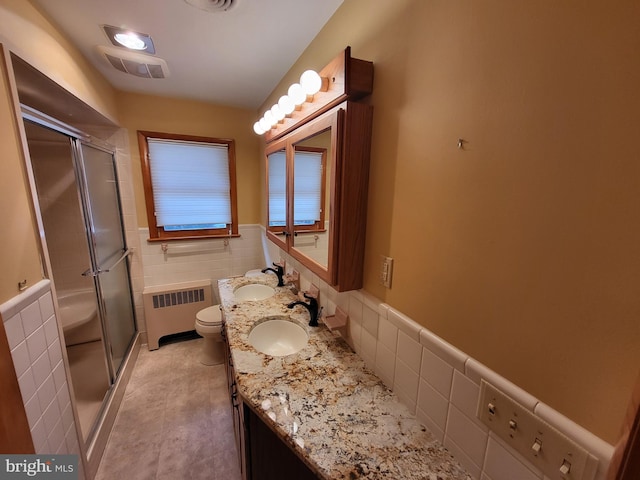 212 University Dr, Mont Alto, PA 17237 - bathroom with radiator heating unit, a sink, tile walls, and a shower stall
