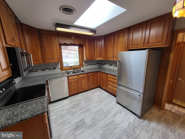 212 University Dr, Mont Alto, PA 17237 - kitchen with a sink, brown cabinets, stainless steel appliances, visible vents, and dark stone counters