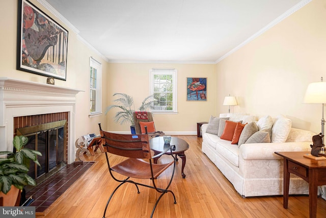 living area featuring wood finished floors, crown molding, a brick fireplace, and baseboards