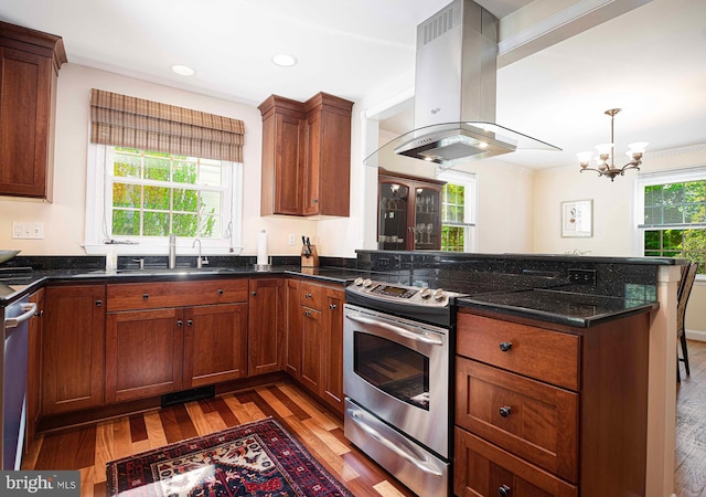 kitchen featuring island exhaust hood, stainless steel appliances, a peninsula, light wood finished floors, and recessed lighting
