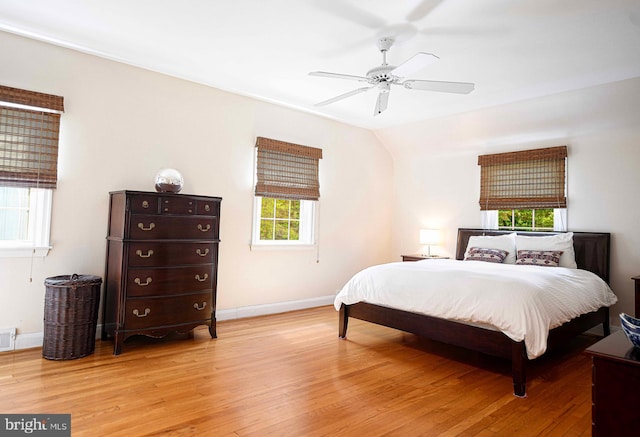 bedroom featuring light wood-style floors, baseboards, and a ceiling fan