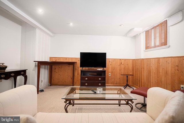 carpeted living area featuring a wainscoted wall, a wall mounted air conditioner, and wood walls