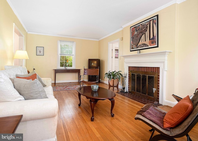 living area with a brick fireplace, light wood finished floors, crown molding, and baseboards