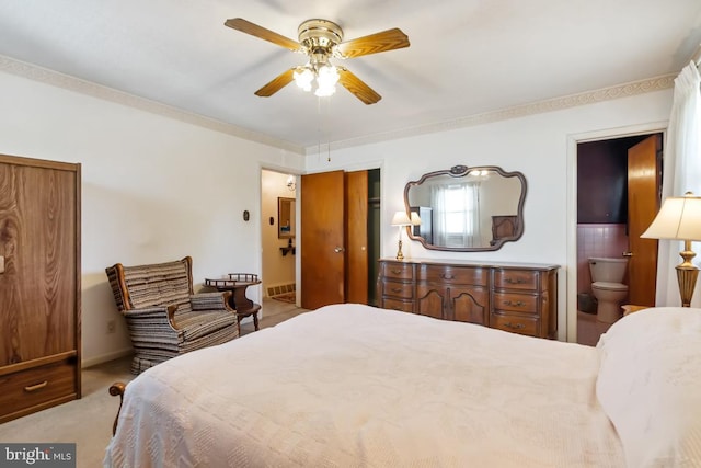 carpeted bedroom featuring a ceiling fan, baseboards, ensuite bathroom, and a closet