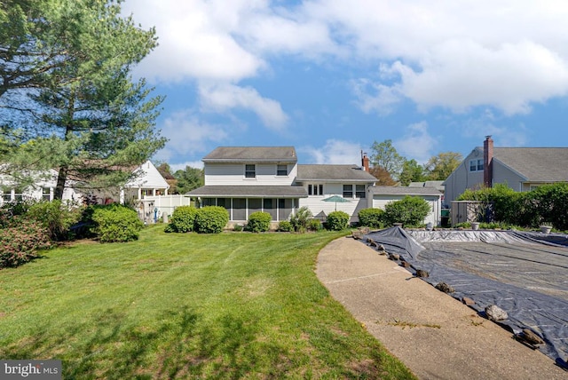 view of front facade featuring a front lawn and fence