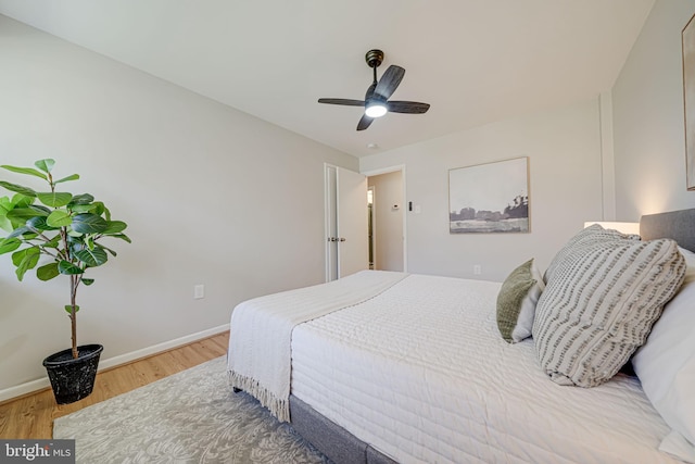 bedroom with baseboards, ceiling fan, and wood finished floors