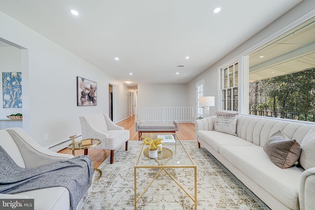 living room with baseboards, a baseboard heating unit, recessed lighting, and light wood-type flooring
