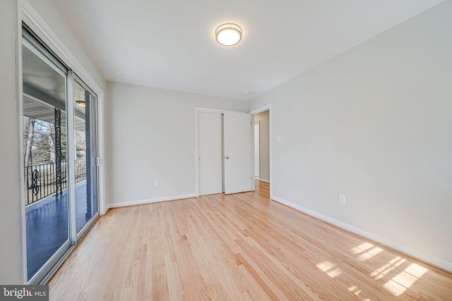 unfurnished room with baseboards and light wood-style flooring