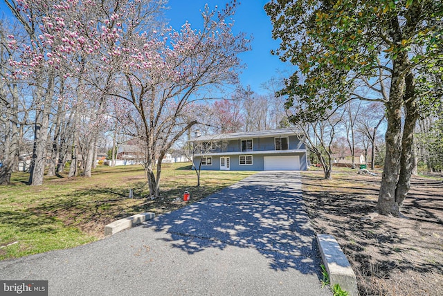view of front of home with driveway, a front lawn, and an attached garage
