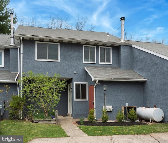 view of front facade with heating fuel and stucco siding