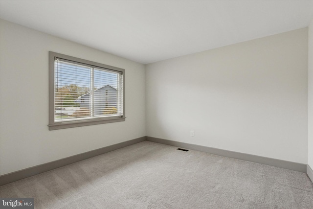 spare room featuring visible vents, baseboards, and carpet flooring