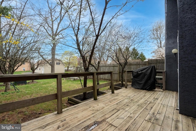 deck with a grill, a lawn, and fence