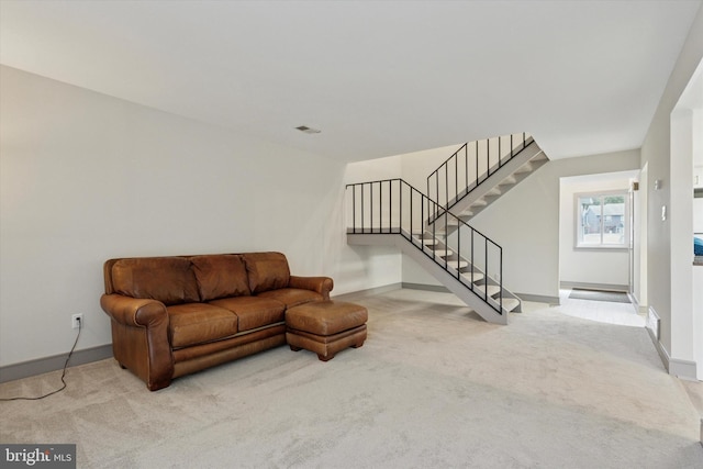 carpeted living area featuring visible vents, baseboards, and stairway