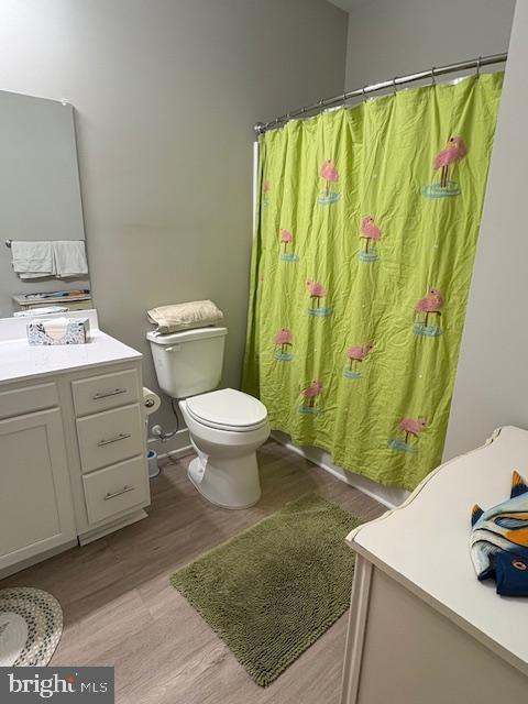 30609 Cedar Neck Rd Unit 3109, Ocean View, DE 19970 - bathroom with curtained shower, wood finished floors, toilet, and vanity