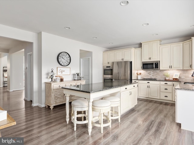 162 Blackford Dr, Stephenson, VA 22656 - kitchen with dark stone counters, a kitchen island, tasteful backsplash, appliances with stainless steel finishes, and cream cabinets