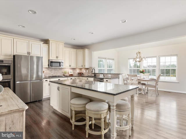162 Blackford Dr, Stephenson, VA 22656 - kitchen with tasteful backsplash, an inviting chandelier, stainless steel appliances, dark stone counters, and cream cabinets