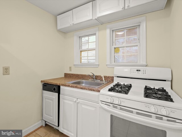 kitchen with dishwasher, white gas range oven, a sink, and white cabinetry