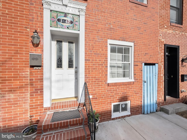 doorway to property featuring brick siding