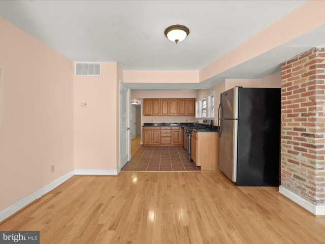 kitchen featuring baseboards, visible vents, light wood-style floors, and appliances with stainless steel finishes
