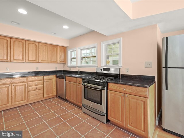 kitchen with light brown cabinetry, recessed lighting, appliances with stainless steel finishes, a sink, and light tile patterned floors