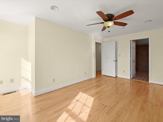 unfurnished bedroom with baseboards, visible vents, light wood-style flooring, and ensuite bathroom