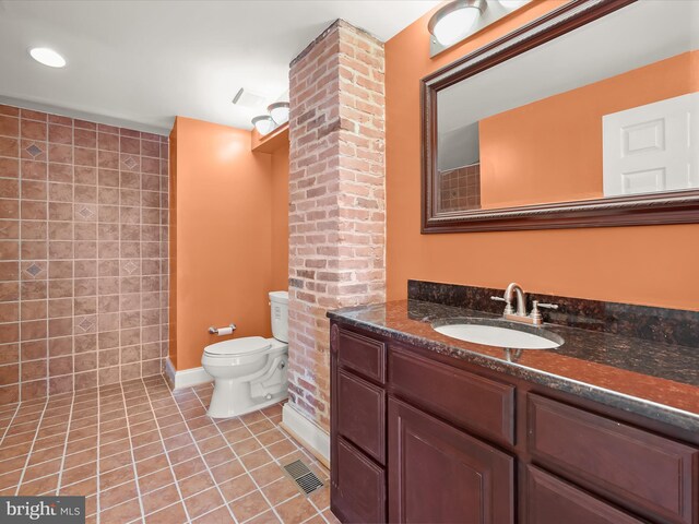 full bath featuring tile patterned floors, toilet, vanity, baseboards, and visible vents