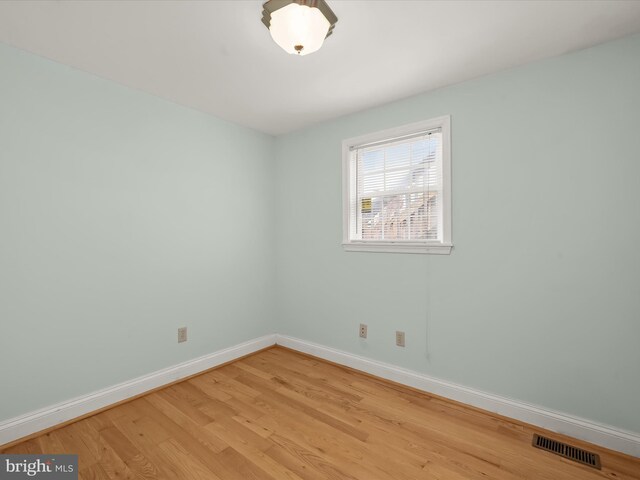 spare room with light wood-style floors, baseboards, and visible vents