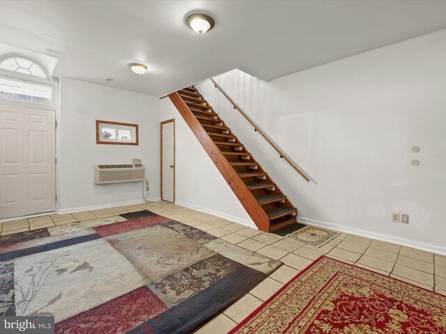 foyer entrance with baseboards, tile patterned flooring, and stairway