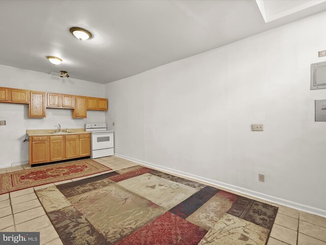 kitchen with light countertops, white range with electric stovetop, light tile patterned floors, baseboards, and a sink