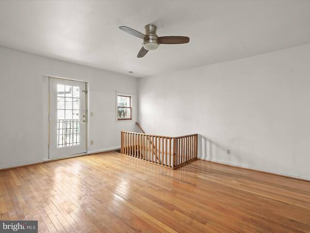 spare room with baseboards, a ceiling fan, and hardwood / wood-style flooring