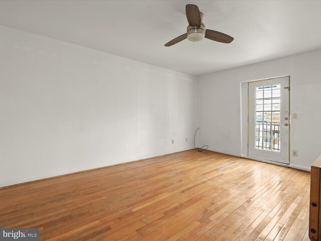 empty room featuring baseboards, ceiling fan, and light wood-type flooring