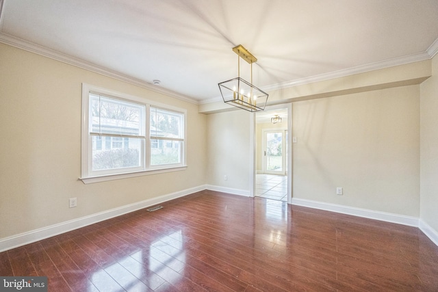 empty room featuring a wealth of natural light, ornamental molding, and dark wood finished floors