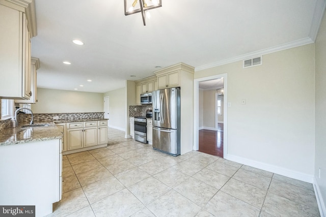 kitchen with decorative backsplash, visible vents, cream cabinetry, appliances with stainless steel finishes, and a sink