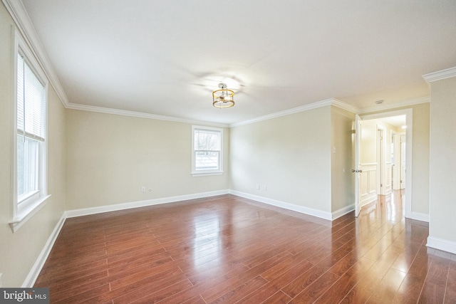 empty room with an inviting chandelier, dark wood-style flooring, crown molding, and baseboards