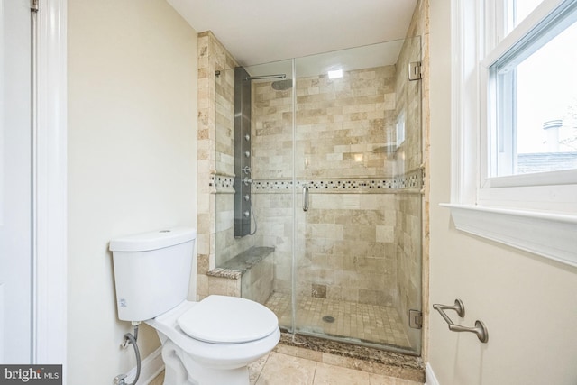 bathroom with a shower stall, tile patterned floors, and toilet
