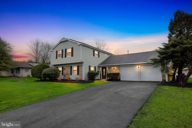 colonial inspired home with a front lawn, driveway, stone siding, and a garage