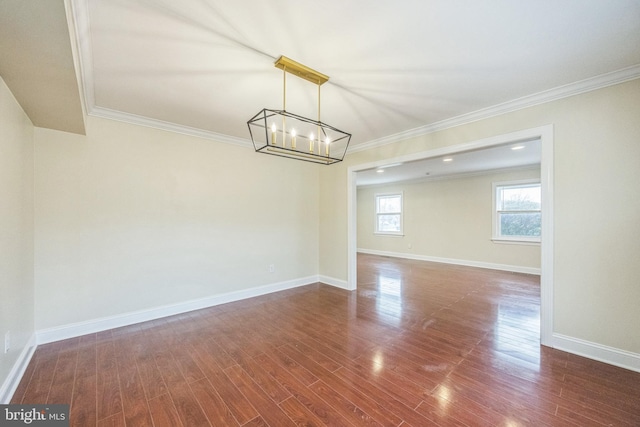 unfurnished room with dark wood-style flooring, ornamental molding, and a chandelier