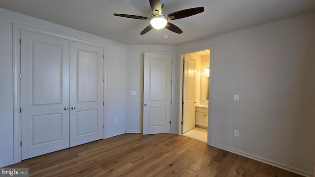unfurnished bedroom featuring a closet, baseboards, a ceiling fan, connected bathroom, and wood finished floors