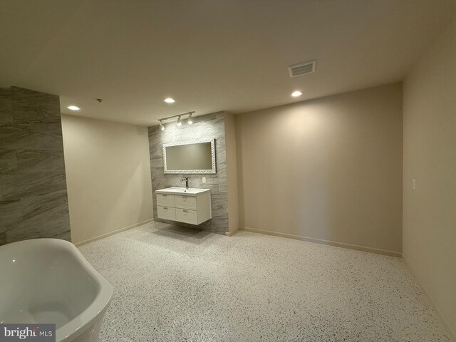 bathroom featuring a soaking tub, rail lighting, vanity, visible vents, and recessed lighting