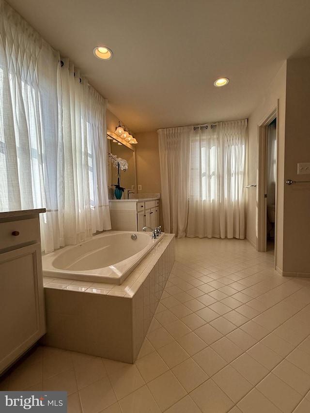 full bath featuring recessed lighting, tile patterned flooring, vanity, and a garden tub
