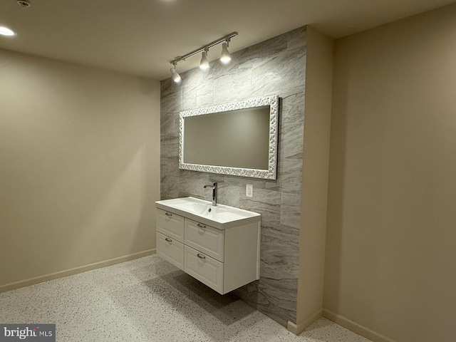 bathroom featuring track lighting, baseboards, an accent wall, recessed lighting, and vanity