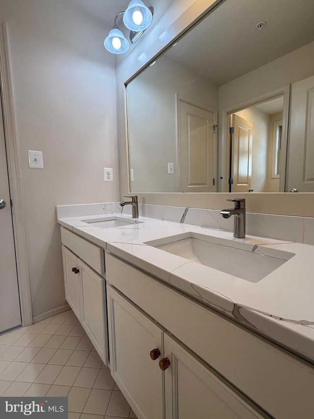bathroom with a sink, double vanity, and tile patterned flooring
