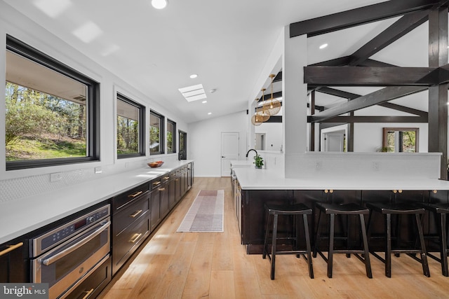 1335 N Pegram St N, Alexandria, VA 22304 - bar featuring light wood-style floors, plenty of natural light, stainless steel oven, and lofted ceiling