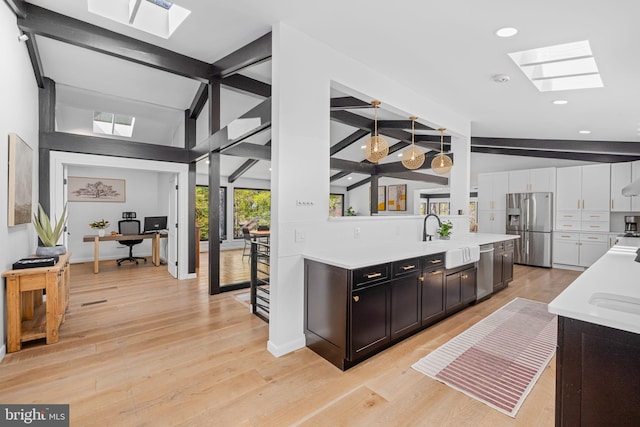1335 N Pegram St N, Alexandria, VA 22304 - interior space featuring light countertops, a sink, lofted ceiling with skylight, and stainless steel appliances