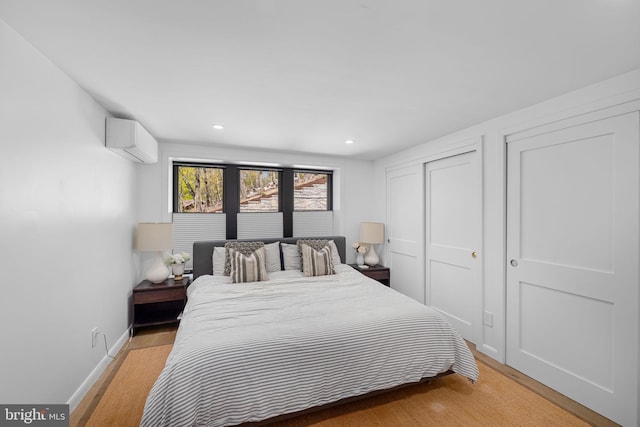 1335 N Pegram St N, Alexandria, VA 22304 - bedroom featuring an AC wall unit, baseboards, recessed lighting, and light wood-style flooring